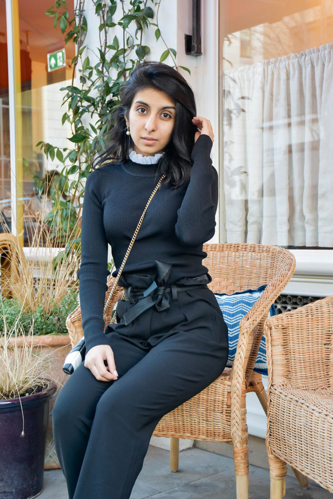 Fashion blogger Shloka Narang of The Silk Sneaker showcases a spring outfit with a spring sweater