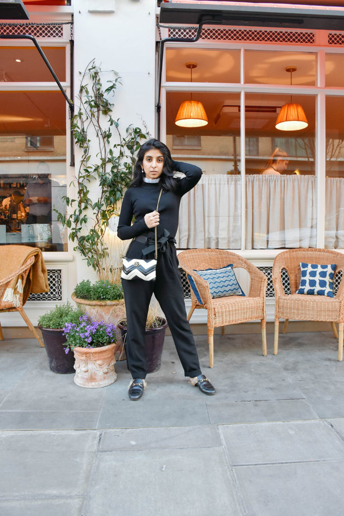 Fashion blogger Shloka Narang of The Silk Sneaker showcases a spring outfit with a spring sweater