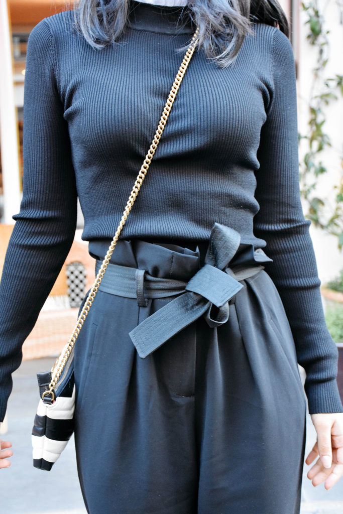Fashion blogger Shloka Narang of The Silk Sneaker showcases a spring outfit with a spring sweater