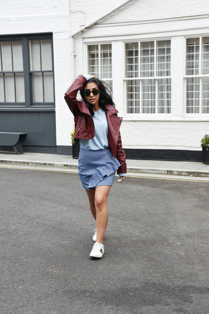 Fashion blogger Shloka Narang of The Silk Sneaker showcases how to wear gingham outfit featuring a Topshop Skirt and Gucci Sneakers