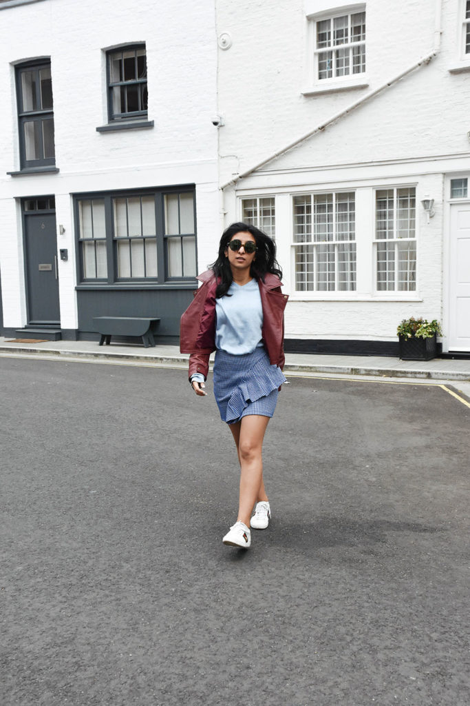 Fashion blogger Shloka Narang of The Silk Sneaker showcases how to wear gingham outfit featuring a Topshop Skirt and Gucci Sneakers