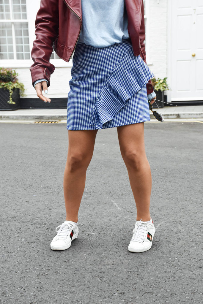 Fashion blogger Shloka Narang of The Silk Sneaker showcases how to wear gingham featuring a Topshop Skirt and Gucci Sneakers