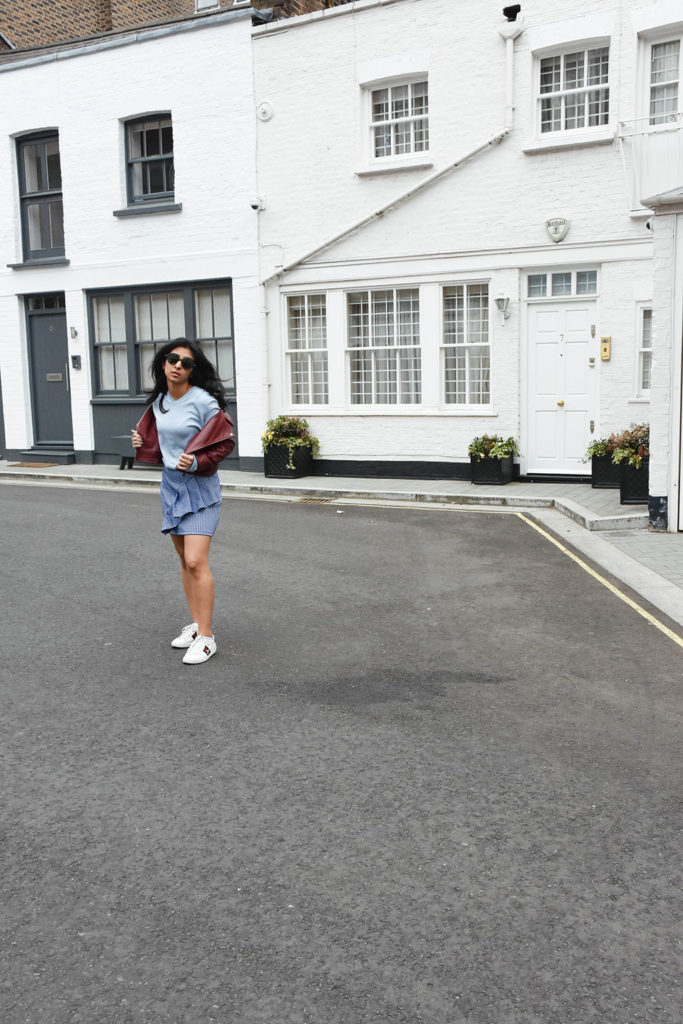 Fashion blogger Shloka Narang of The Silk Sneaker showcases how to wear gingham outfit featuring a Topshop Skirt and Gucci Sneakers