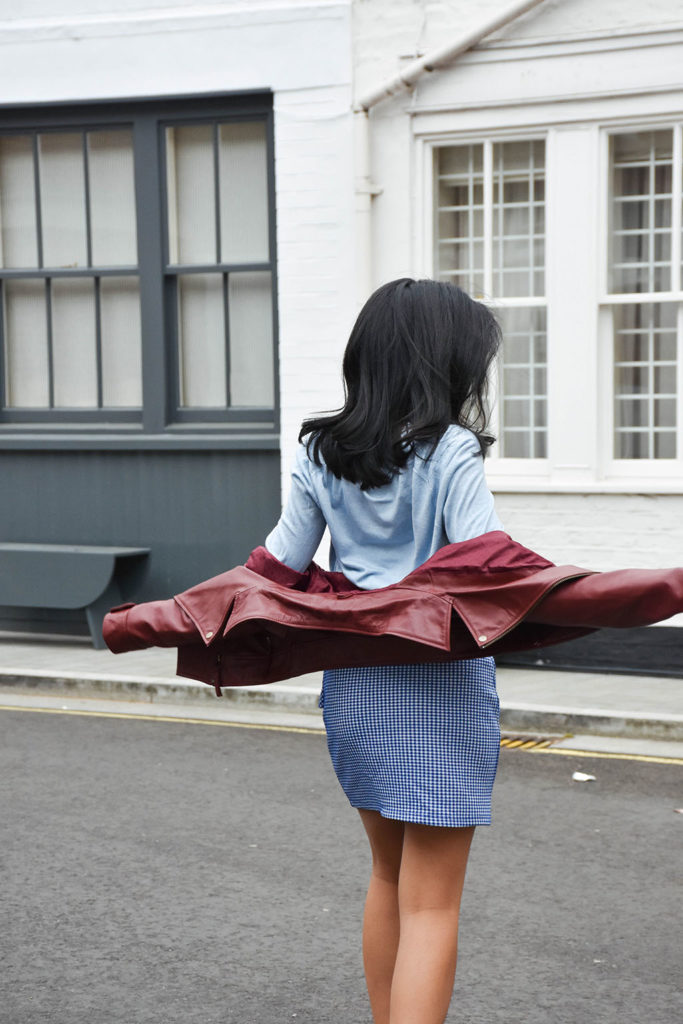 Fashion blogger Shloka Narang of The Silk Sneaker showcases how to wear gingham outfit featuring a Topshop Skirt and Gucci Sneakers