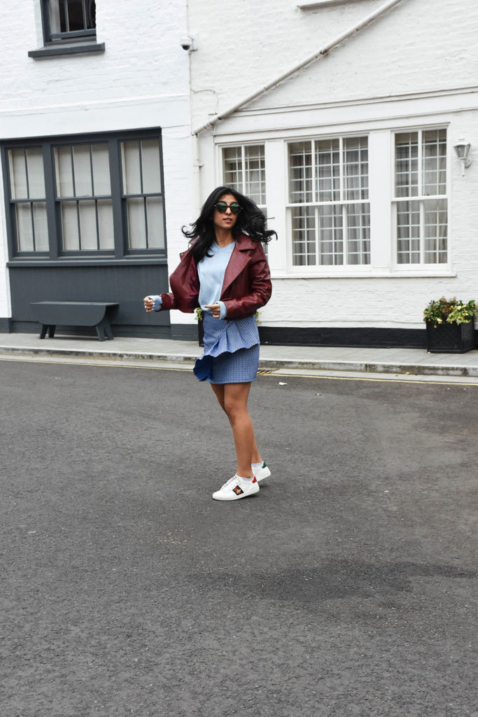 Fashion blogger Shloka Narang of The Silk Sneaker showcases how to wear gingham outfit featuring a Topshop Skirt and Gucci Sneakers