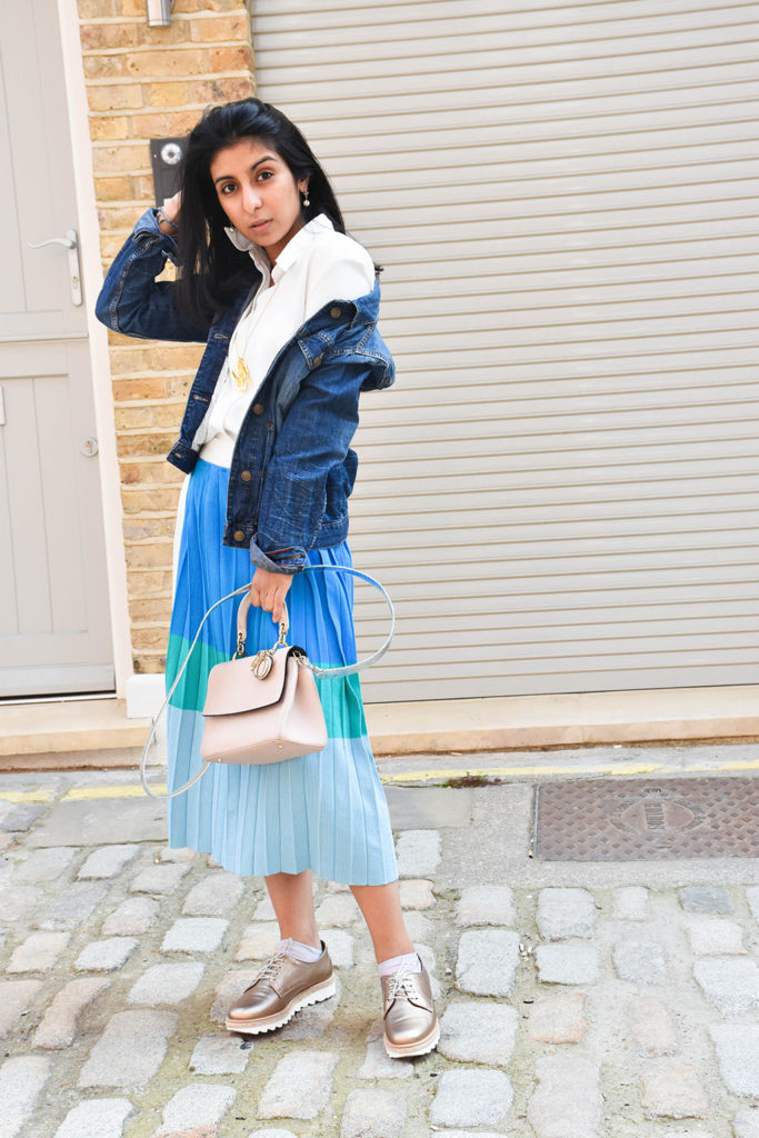 Fashion blogger Shloka Narang styles a maxi skirt outfit featuring a pastel colour block skirt and denim jacket