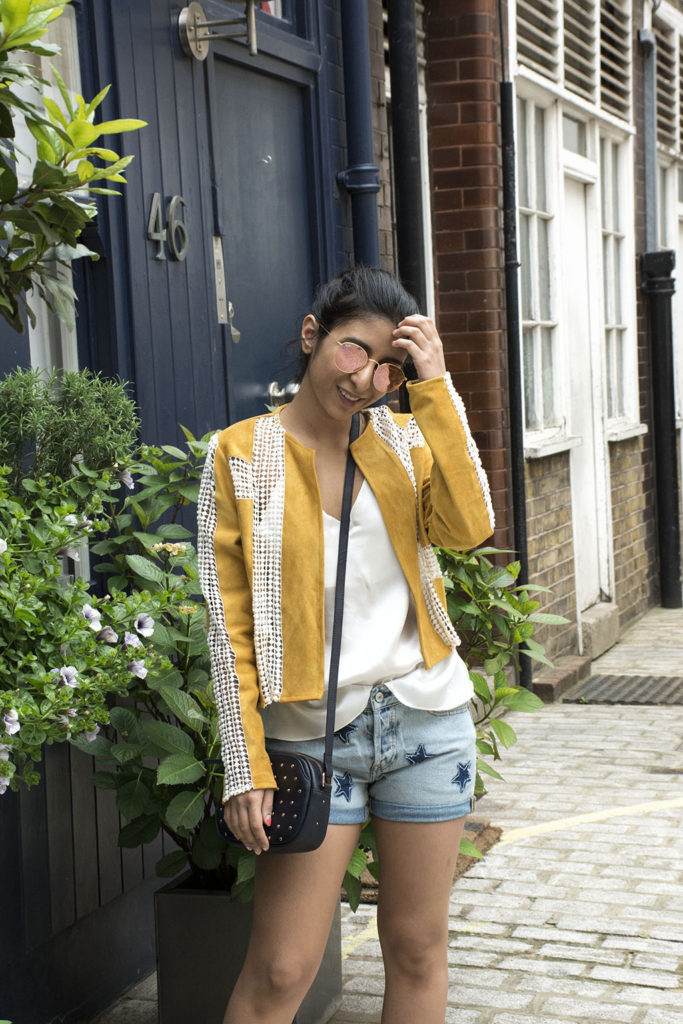 Fashion Blogger Shloka Narang of The Silk Sneaker showcases how to wear statement pieces with denim shorts and Radley Bag