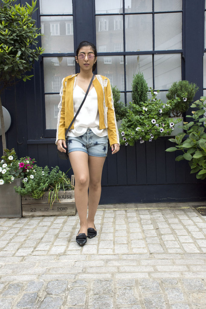 Fashion Blogger Shloka Narang of The Silk Sneaker showcases how to wear statement pieces with denim shorts and Radley Bag