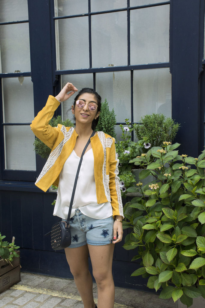 Fashion Blogger Shloka Narang of The Silk Sneaker showcases how to wear statement pieces with denim shorts and Radley Bag
