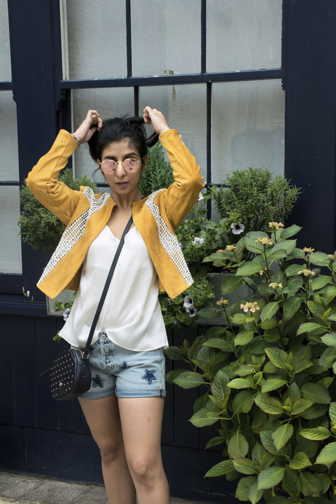 Fashion Blogger Shloka Narang of The Silk Sneaker showcases how to wear statement pieces with denim shorts and Radley Bag