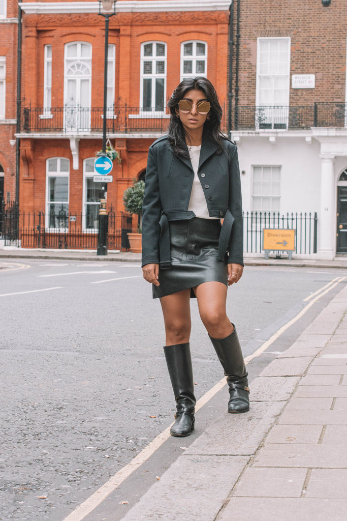 Fashion blogger Shloka Narang of the Silk Sneaker showcases a leather skirt winter outfit featuring Zara, Maje and Dior