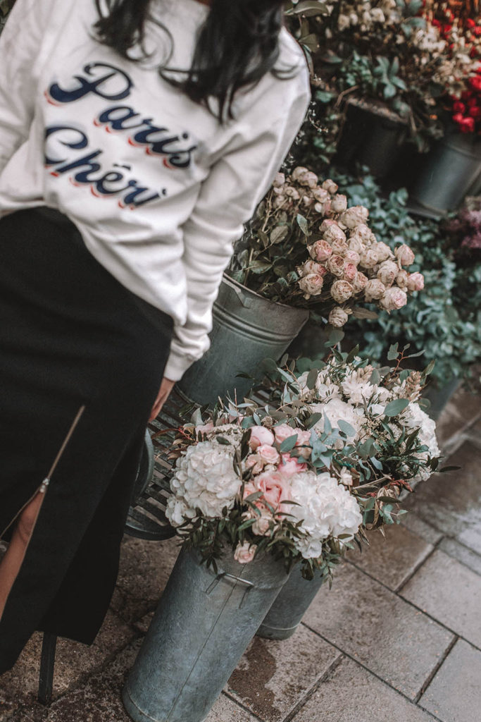 Fashion blogger Shloka Narang of The Silk Sneaker shares a style trick for how to style a statement sweater for a cozy and cute spring summer outfit featuring Ba&sh and Chanel