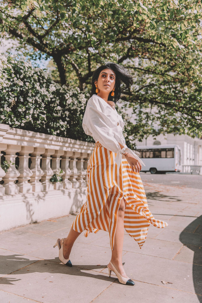 Fashion blogger Shloka Narang of The Silk Sneaker shares how to style the two most popular high street pieces under £100 in one summer outfit including a striped maxi skirt from Topshop and a white Zara top with Chanel vintage slingback heels.
