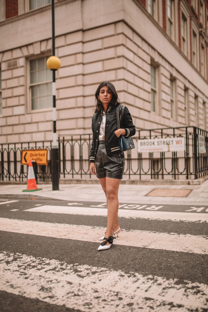 Luxury fashion blogger Shloka Narang of The Silk Sneaker shares how to style a trending piece for autumn winter 2018, leather shorts, featuring Chanel, Saint Laurent and Mango