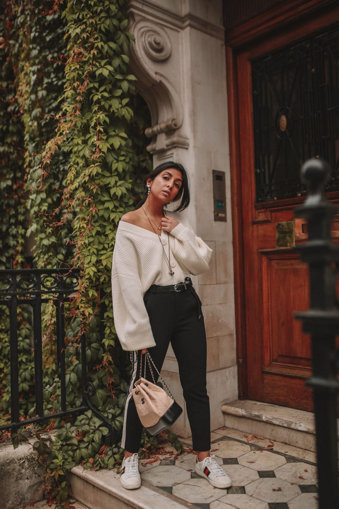 Luxury fashion blogger Shoka Narang of The Silk Sneaker shares how to style an oversized knit cardigan for a cute winter outfit with & Other Stories, Chanel backpack and Gucci Sneakers