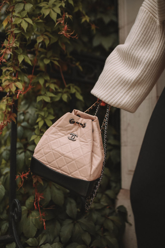 Luxury fashion blogger Shoka Narang of The Silk Sneaker shares how to style an oversized knit cardigan for a cute winter outfit with & Other Stories, Chanel backpack and Gucci Sneakers