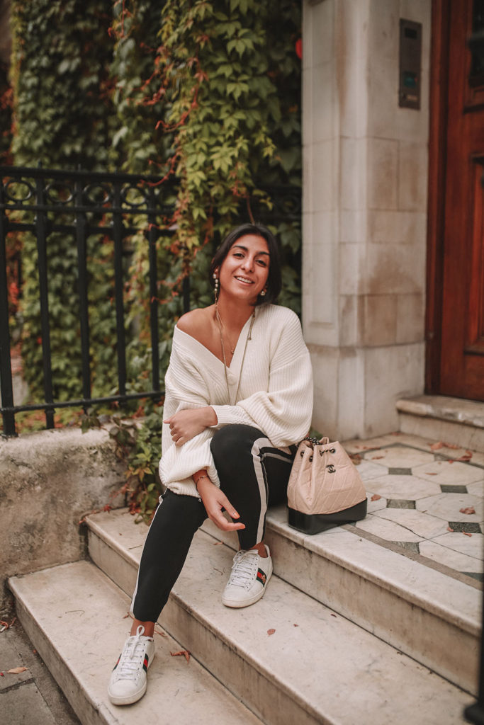 Luxury fashion blogger Shoka Narang of The Silk Sneaker shares how to style an oversized knit cardigan for a cute winter outfit with & Other Stories, Chanel backpack and Gucci Sneakers