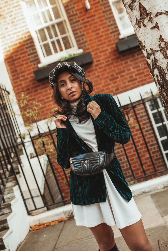 Luxury fashion blogger Shloka Narang of The Silk Sneaker shares how to wear a belt bag with a Prada belt bag, ASOS dress and velvet blazer for a winter outfit