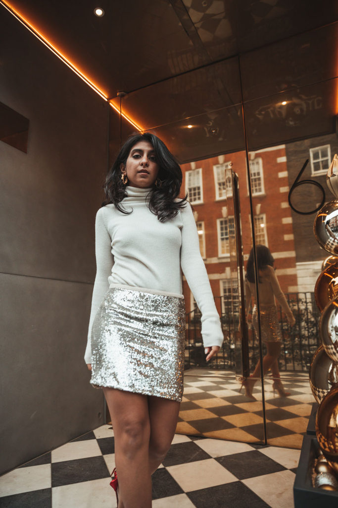 Luxury fashion blogger Shloka Narang of The Silk Sneaker shares a holiday party outfit idea featuring a sequins skirt from Topshop and Gianvitto Rossi heels