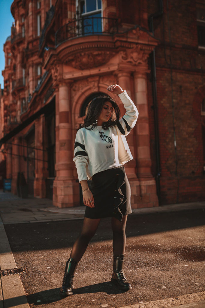 Luxury fashion blogger Shloka Narang of The Silk Sneaker shares her casual winter outfit ideas for a cute outfit featuring Miu Miu, black combat boots and a Zara Skirt