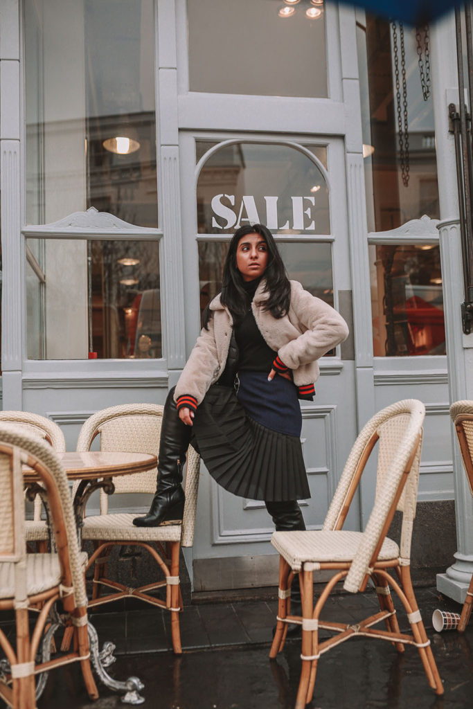 Luxury fashion blogger Shloka Narang of The Silk Sneaker shares how to style a pleated skirt in the winter for a casual outfit featuring Givenchy and Farfetch