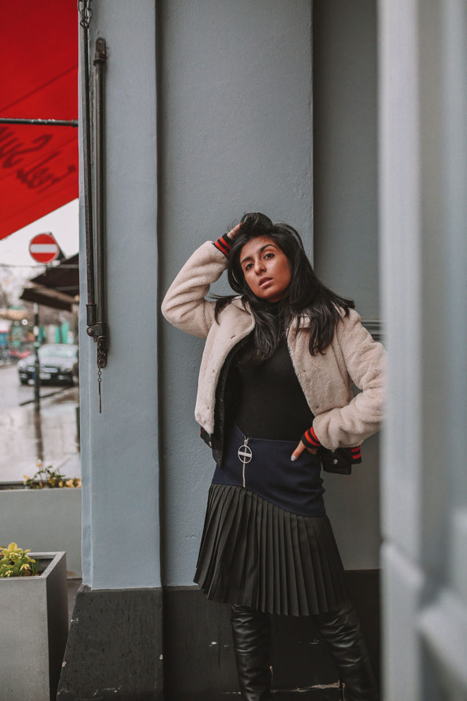 Luxury fashion blogger Shloka Narang of The Silk Sneaker shares how to style a pleated skirt in the winter for a casual outfit featuring Givenchy and Farfetch