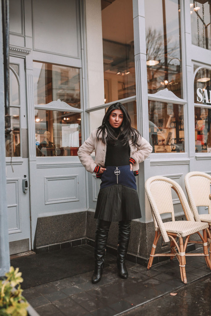 Luxury fashion blogger Shloka Narang of The Silk Sneaker shares how to style a pleated skirt in the winter for a casual outfit featuring Givenchy and Farfetch