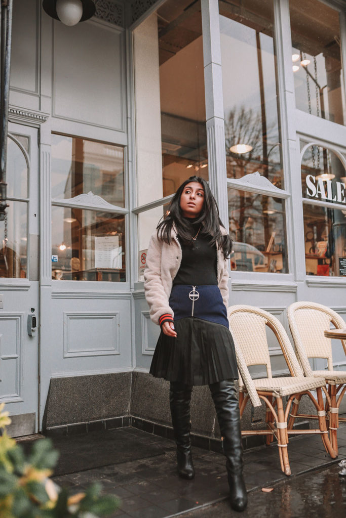 Luxury fashion blogger Shloka Narang of The Silk Sneaker shares how to style a pleated skirt in the winter for a casual outfit featuring Givenchy and Farfetch