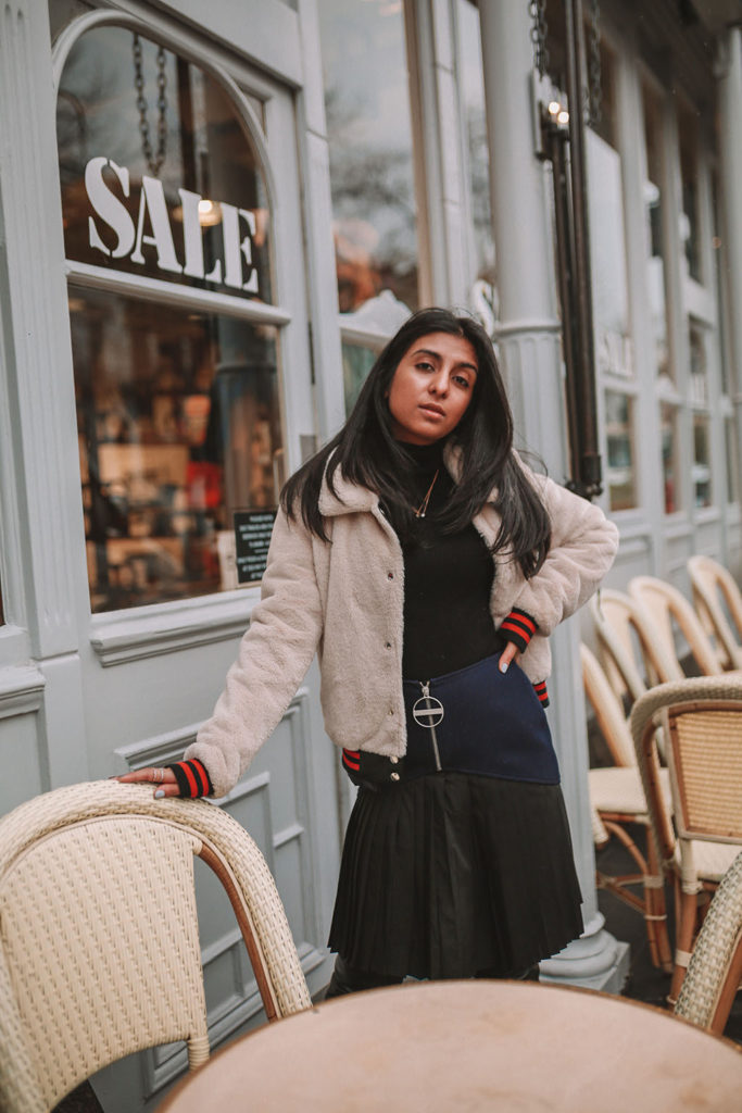 Luxury fashion blogger Shloka Narang of The Silk Sneaker shares how to style a pleated skirt in the winter for a casual outfit featuring Givenchy and Farfetch