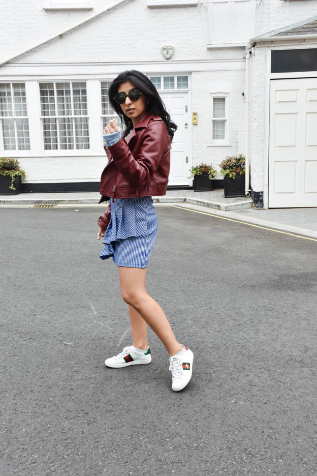 Fashion blogger Shloka Narang of The Silk Sneaker showcases how to wear gingham outfit featuring a Topshop Skirt and Gucci Sneakers
