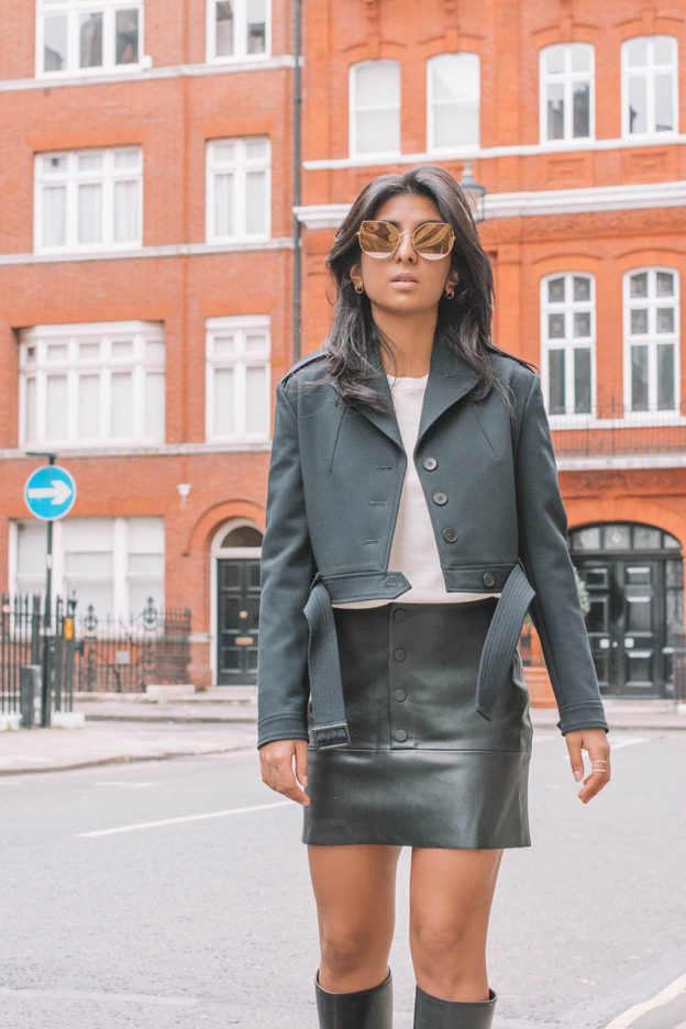 Fashion blogger Shloka Narang of the Silk Sneaker showcases a leather skirt winter outfit featuring Zara, Maje and Dior