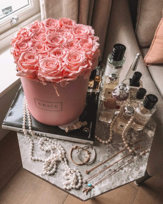 Fashion blogger Shloka Narang creates a fashion flatlay with roses and flowers and perfumes