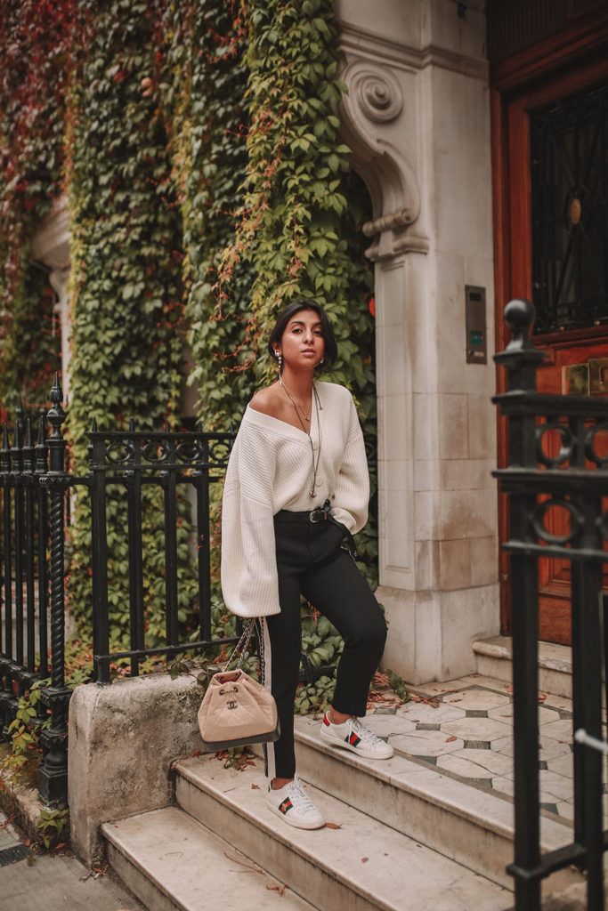 Luxury fashion blogger Shoka Narang of The Silk Sneaker shares how to style an oversized knit cardigan for a cute winter outfit with & Other Stories, Chanel backpack and Gucci Sneakers