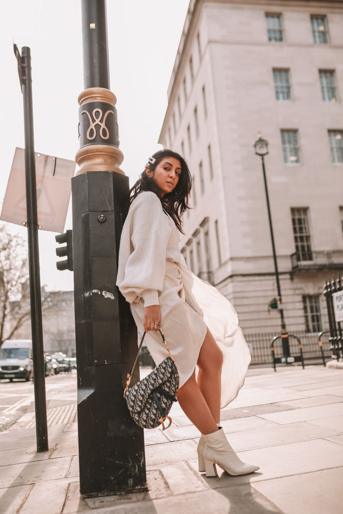 Luxury fashion blogger Shloka Narang of The Silk Sneaker shares how to create the perfect spring outfit to transition your wardrobe this March featuring a silk slip skirt, Dior Saddle bag and pearl hair clips