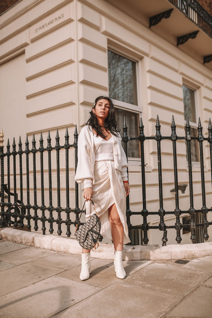 Luxury fashion blogger Shloka Narang of The Silk Sneaker shares how to create the perfect spring outfit to transition your wardrobe this March featuring a silk slip skirt, Dior Saddle bag and pearl hair clips