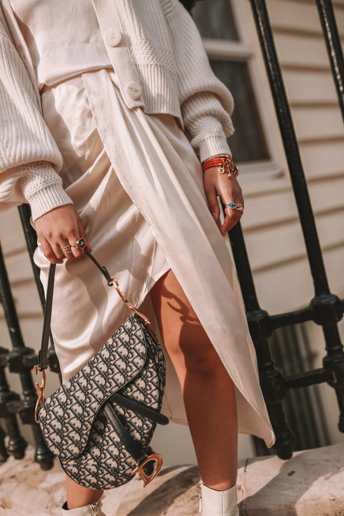 Luxury fashion blogger Shloka Narang of The Silk Sneaker shares how to create the perfect spring outfit to transition your wardrobe this March featuring a silk slip skirt, Dior Saddle bag and pearl hair clips