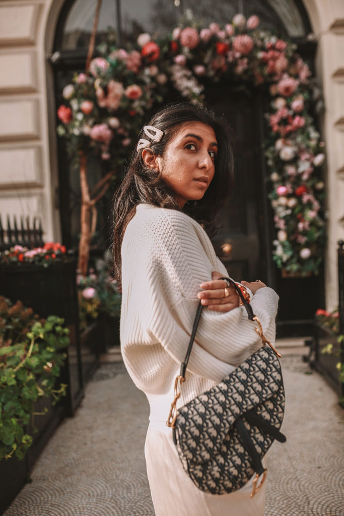 Luxury fashion blogger Shloka Narang of The Silk Sneaker shares how to create the perfect spring outfit to transition your wardrobe this March featuring a silk slip skirt, Dior Saddle bag and pearl hair clips