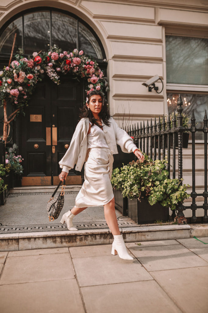 Luxury fashion blogger Shloka Narang of The Silk Sneaker shares how to create the perfect spring outfit to transition your wardrobe this March featuring a silk slip skirt, Dior Saddle bag and pearl hair clips