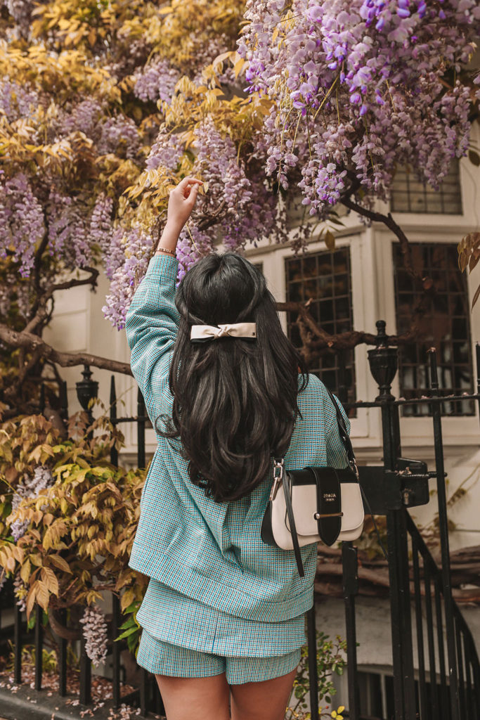 Luxury fashion blogger Shloka Narang of The Silk Sneaker shows how to style matching sets in a Maje coord suit, Prada bag and Valentino Sandals in London with Wysteria