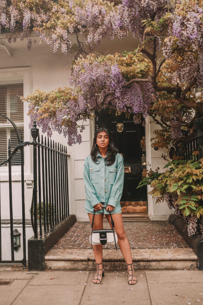 Luxury fashion blogger Shloka Narang of The Silk Sneaker shows how to style matching sets in a Maje coord suit, Prada bag and Valentino Sandals in London with Wysteria