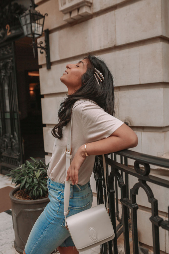 Luxury fashion blogger Shloka Narang of the Silk Sneaker shares how to style denim bicycle shorts in a casual summer outfit featuring YSL, Paige and Zara