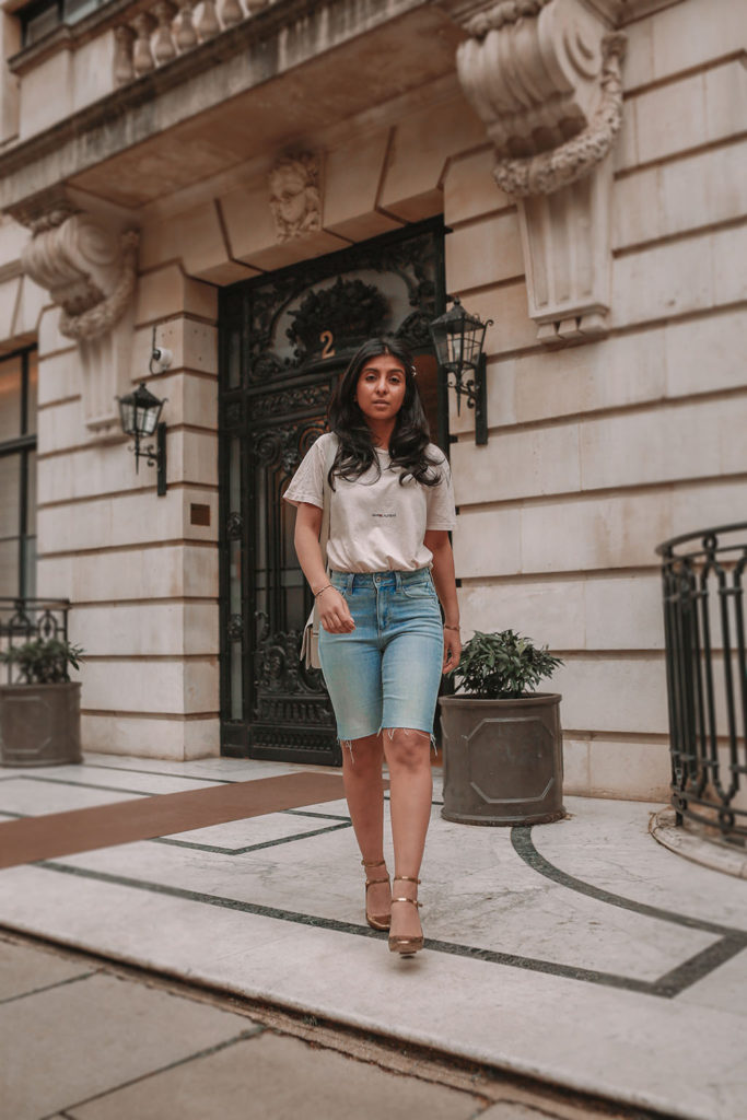 Luxury fashion blogger Shloka Narang of the Silk Sneaker shares how to style denim bicycle shorts in a casual summer outfit featuring YSL, Paige and Zara