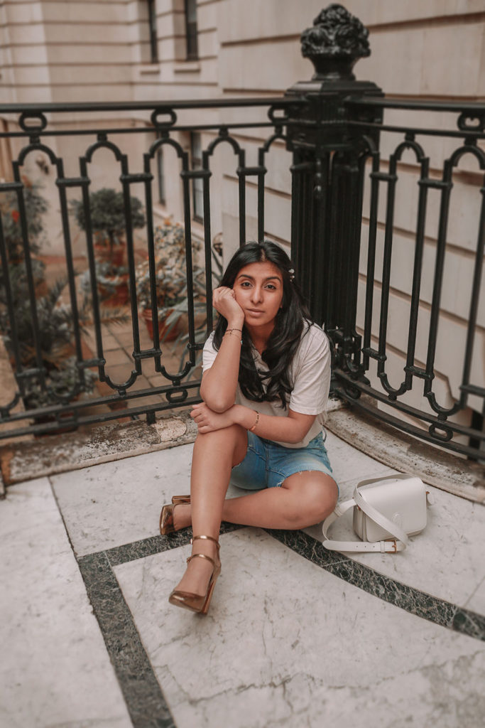 Luxury fashion blogger Shloka Narang of the Silk Sneaker shares how to style denim bicycle shorts in a casual summer outfit featuring YSL, Paige and Zara