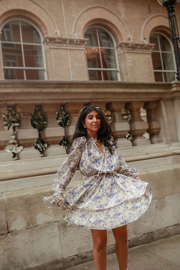 Luxury fashion blogger Shloka Narang of The Silk Sneaker shares how to pair a midi summer dress with sneakers for a casual summer outfit featuring a floral dress from & Other Stories and Veja sneakers
