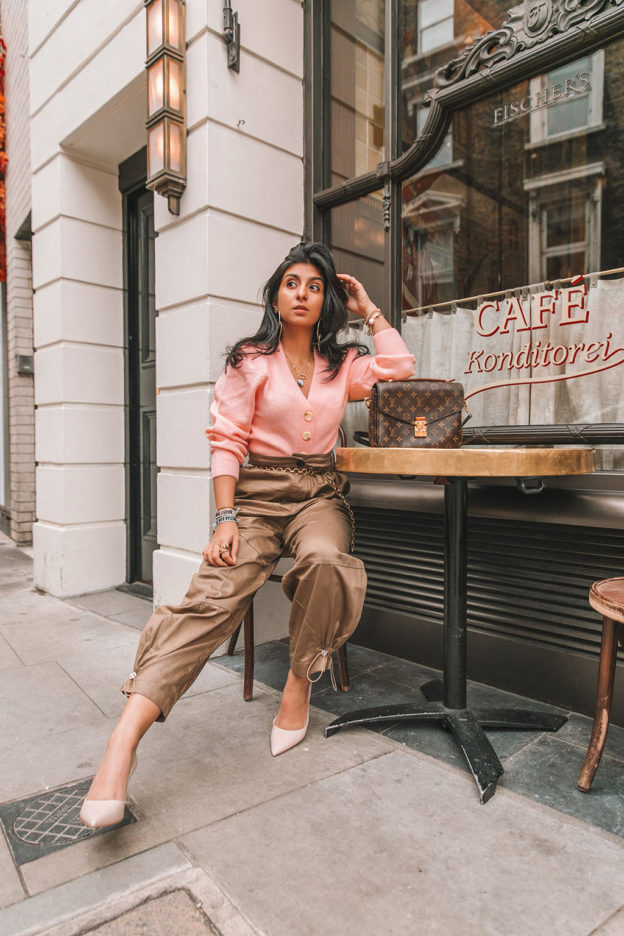 Luxury fashion blogger Shloka Narang of The Silk Sneaker shares how to wear cargo pants featuring cuffed Zara cargo pants and a pink & Other Stories Sweater with a Louis Vuitton Pochette Metis bag