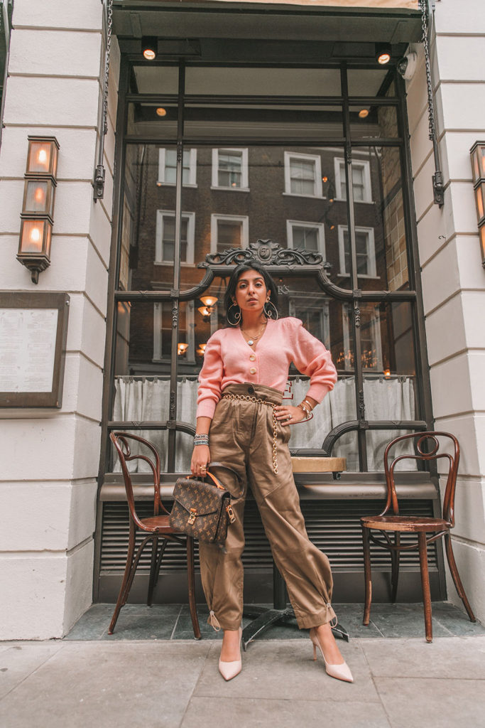 Luxury fashion blogger Shloka Narang of The Silk Sneaker shares how to wear cargo pants featuring cuffed Zara cargo pants and a pink & Other Stories Sweater with a Louis Vuitton Pochette Metis bag