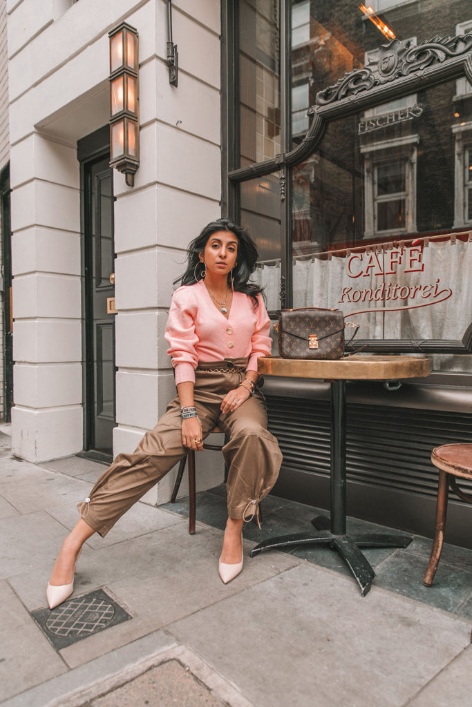 Luxury fashion blogger Shloka Narang of The Silk Sneaker shares how to wear cargo pants featuring cuffed Zara cargo pants and a pink & Other Stories Sweater with a Louis Vuitton Pochette Metis bag