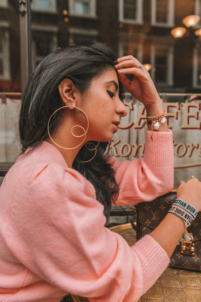 Luxury fashion blogger Shloka Narang of The Silk Sneaker shares how to wear cargo pants featuring cuffed Zara cargo pants and a pink & Other Stories Sweater with a Louis Vuitton Pochette Metis bag