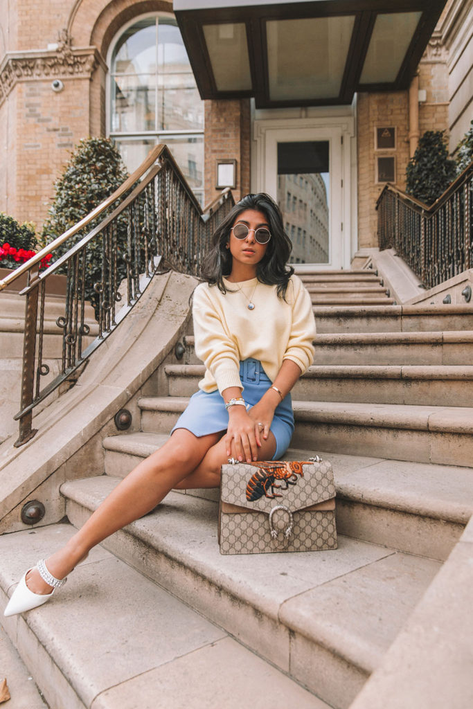 Luxury fashion blogger Shloka Narang of The Silk Sneaker shares three colour trends to wear for your next winter outfit featuring a blue & Other Stories belted skirt and a yellow oversized sweater