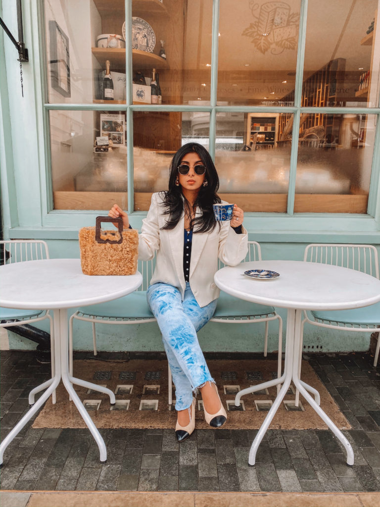 Luxury fashion blogger Shloka Narang of The Silk Sneaker shares an easy winter outfit featuring a Staud bag from Farfetch
